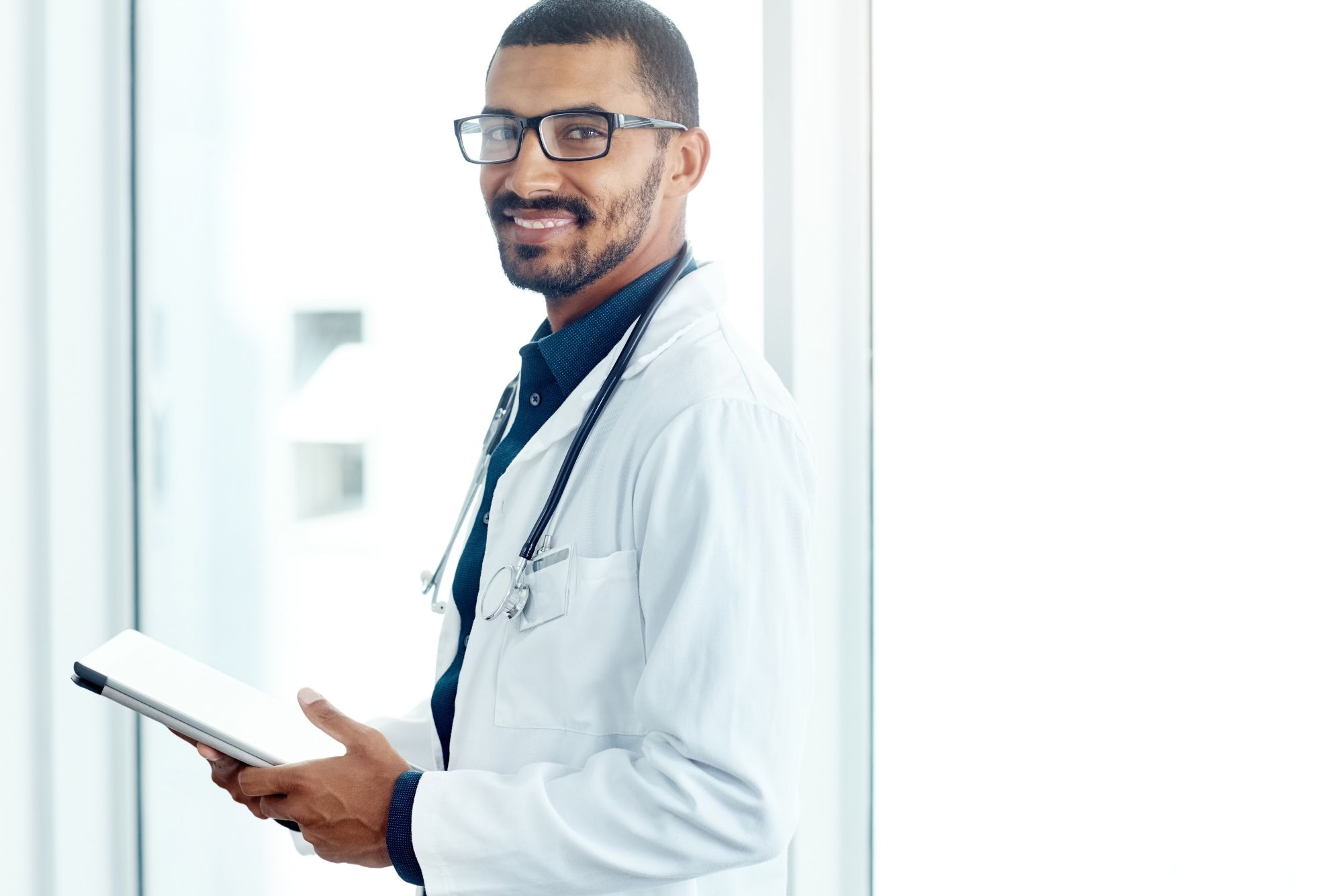 A doctor holding an iPad smiles because his patients are happy to fill out their dynamic forms for appointments.